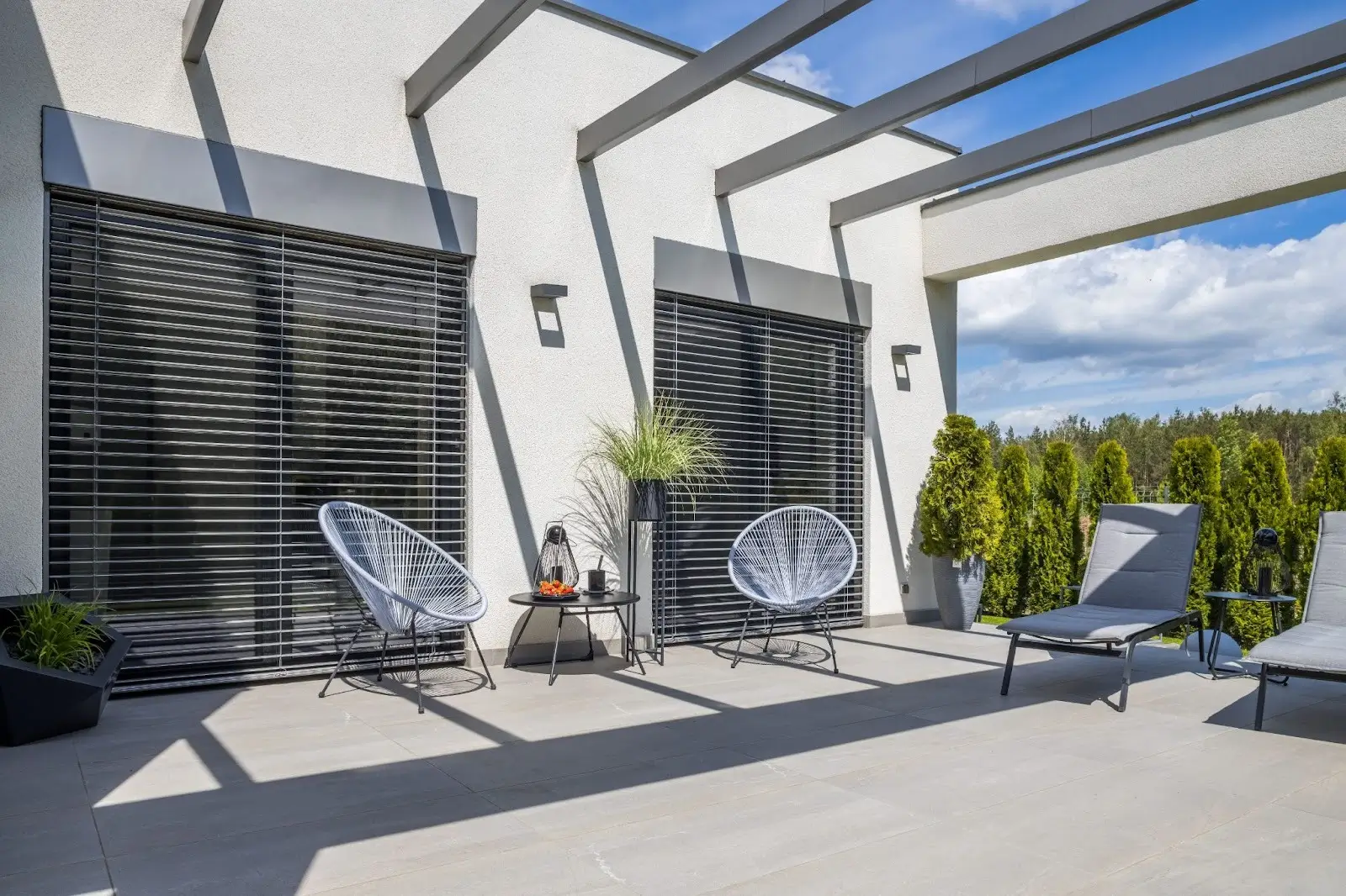 A freshly installed concrete patio set against a white modern home.